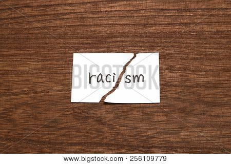 The Paper Written As Racism Is Torn On Wood. Concept Of Abolition Of Racial Discrimination.
