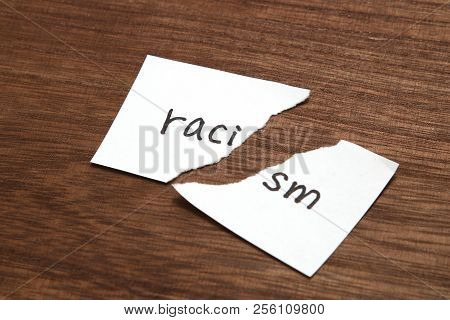 The Paper Written As Racism Is Torn On Wood. Concept Of Abolition Of Racial Discrimination.