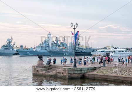 Kronstadt, St. Petersburg, Russia -- July 28, 2018: People On The Pier On The Background Of Naval Sh