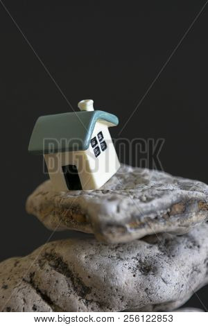 House On The Edge Of The Abyss On A Black Background. The Concept Of A Dangerous Situation In Life A