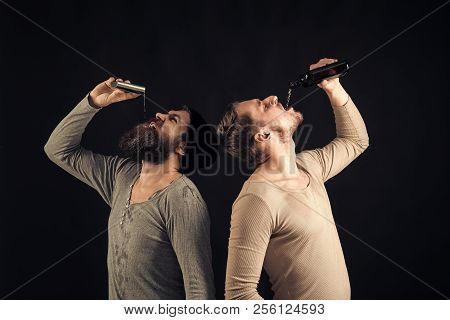 Company Of Dirty Friends Spend Leisure With Drinks. Men On Drunk Faces, Dark Background. Guys Hold B