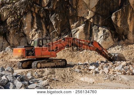 Orange Tracked Earth Mover In A Marble Quarry (carrara White Marble) In The Apuan Alps (alpi Apuane)