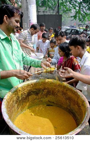 DELHI - 20 de outubro: Pessoas com uma refeição gratuita em 20 de outubro de 2007 em Delhi, Índia. Em g de Deus