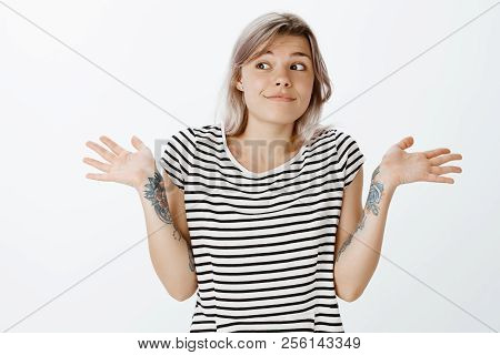 Who Cares, I Know Nothing. Portrait Of Indifferent Carefree Cute Woman With Fair Hair And Tattoos, S