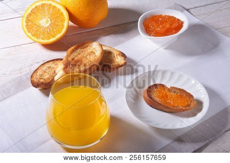 Morning Breakfast Set With Orange Jam On Bread Toast And Juice In Glass.