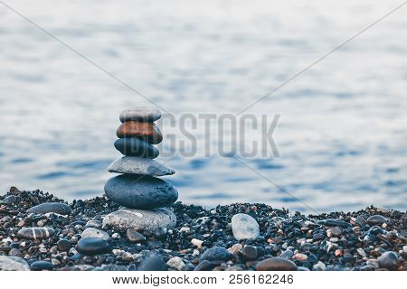 Pyramid Of Pebbles On The Beach.waves In Background.