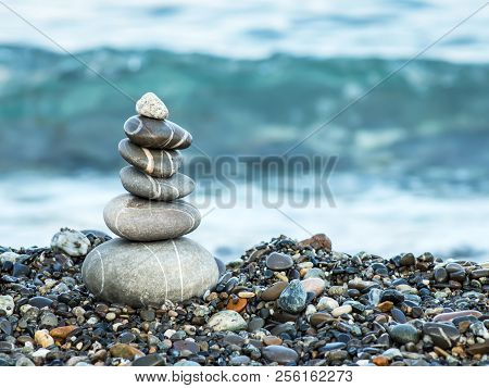 Pyramid Of Pebbles On The Beach.waves In Background.