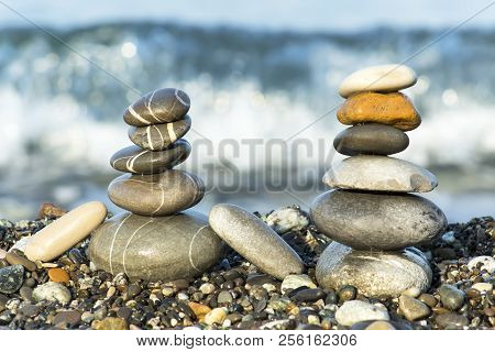 Pyramid Of Pebbles On The Beach.waves In Background.