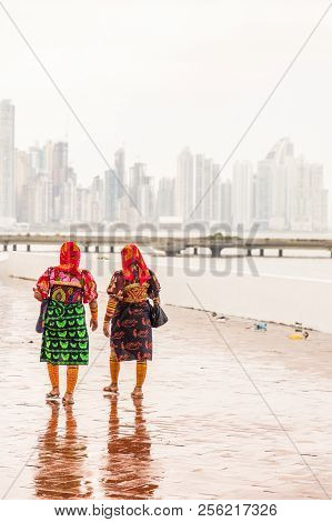Panama City, Panama. March 2018. A View Of Colorfully Dressed Kuna Yala Women Against The City Skyli