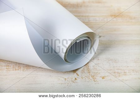 Roll Of White Paper On A Wooden Background.