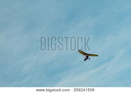 The Hang-glider On A Background Blue Sky With Light Clouds. Flying A Gyroplane.