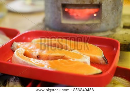 Raw Salmon Fish Fillet On Red Tray Ready To Cook In Grill Buffet