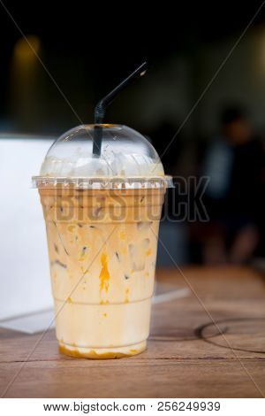 Caramel Macchiato Iced Coffee With Straw On Wooden Tabel