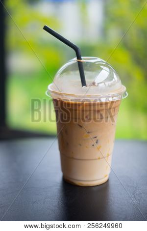 Ice Caramel Mochiato In Takeaway Cup On Black Table