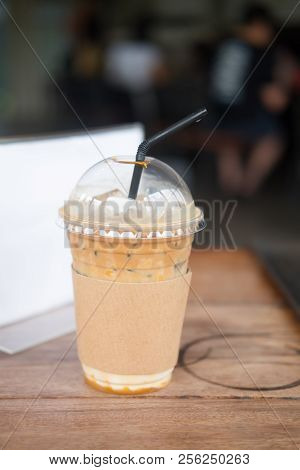 Caramel Macchiato Iced Coffee With Straw On Wooden Table