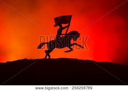 World War Officer (or Warrior) Rider On Horse With A Sword Ready To Fight And Soldiers On A Dark Fog