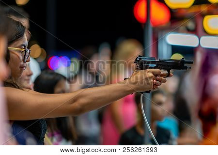 Durres Albania, August 5, 2018: Night Side View Of A Young Woman Shooting With Airsoft Semi-automati