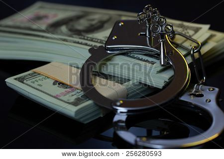 Handcuffs And Money In The Darkness. Concept Of Business Fraud And Corruption.