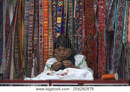 Otavalo, Ecuador - July 5, 2012: Indian Women In National Clothes Sells The Products Of Her Weaving,