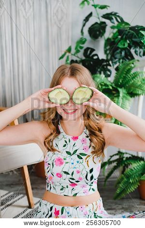 Portrait Of A Young Cute Woman Covering Her Eyes With A Cut Halfs Of Avocado