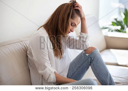 Sad Depressed Woman Feeling Bad At Home Sitting On Sofa