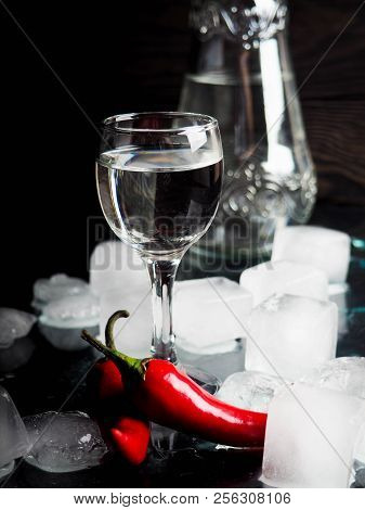 A Shot Of Vodka, An Alcoholic Beverage, Next To Ice, Fire, Ice, Red Chili Pepper. The Concept Of Alc