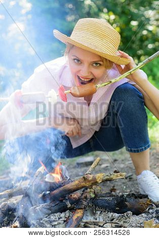 Woman In Straw Hat Try To Bite Sausage On Stick. She Has Strong Appetite. Woman Want Eat Sausage Pic