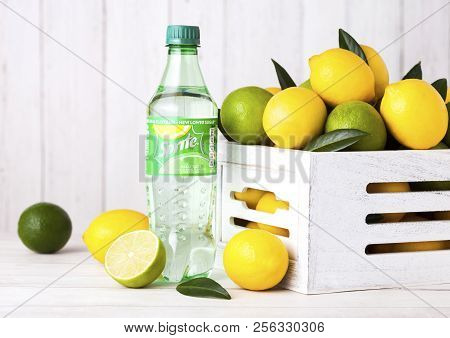 London, Uk - September 03, 2018: Bottle Of Sprite Drink On Wooden Background With Lemons And Limes. 