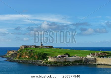 Scenic View Of Historic Colorful Puerto Rico City In Distance With Fort In Foreground From The Sea C