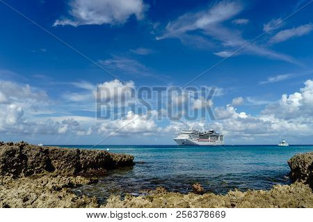 Cruise Ship In Crystal Blue Water With A Rock On The Front