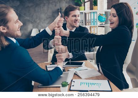 Three Excited Elegant Classic Business Sharks, Businesspeople In Suits Putting Their Hands With Thum