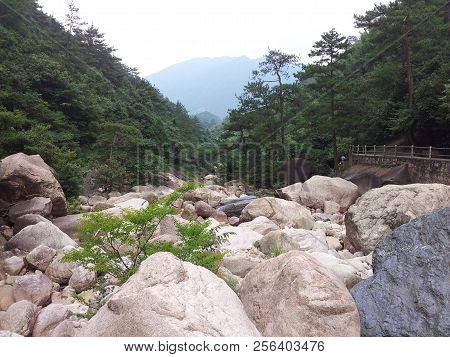 Photographed In The Huangshan Scenic Area In China, There Is A Huge Stone On The Green Hillside.