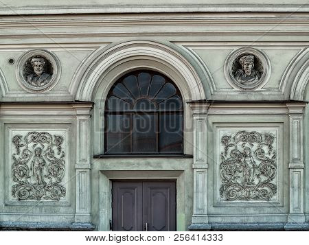 On The Facade Of The Building In The City Of St. Petersburg Is A Round Arched Window With Dark Glass