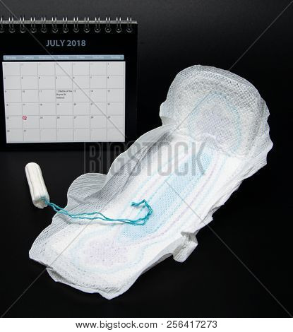 Reading, United Kingdom - July 08 2018:   A Tampon And A Sanitary Towel In Front Of A Calendar With 
