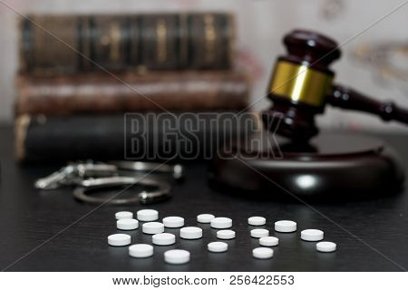 Judge's Gavel With Handcuffs, Drugs On Wooden Table