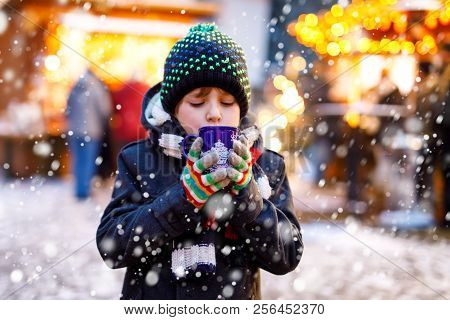 Little Cute Kid Boy Drinking Hot Children Punch Or Chocolate On German Christmas Market. Happy Child