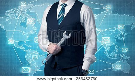 Businessman holding tool with global map graphic on the background
