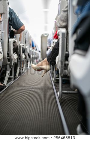 Interior of commercial airplane with passengers in their seats during flight.