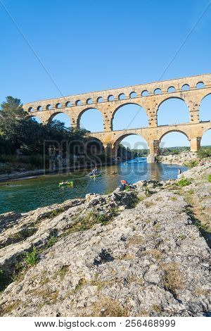 Remoulins,france-august 12, 2016:people Swim And Canoe Near The Pont Du Gard Roman Aqueduct During A