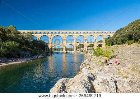 Remoulins,france-august 12, 2016:people Swim And Canoe Near The Pont Du Gard Roman Aqueduct During A