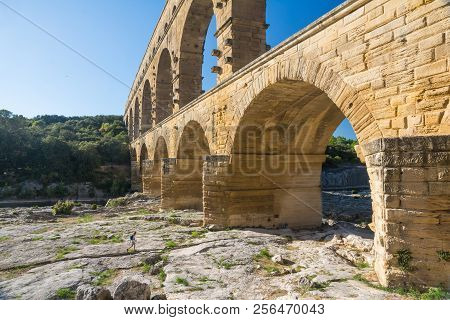 Remoulins,france-august 12, 2016:people Swim And Canoe Near The Pont Du Gard Roman Aqueduct During A