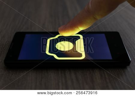 Moscow, Russia - August 19, 2018: Smartphone On Table Displaying Logo Of 123rf App. Finger Above Tou