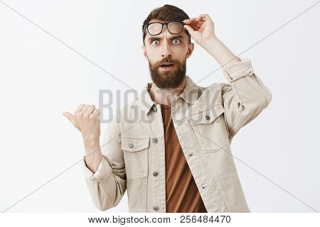 Waist-up Shot Of Concerned Questioned Handsome Mature Male With Beard Taking Off Glasses Staring Sho