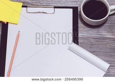 A Close Up Of Workplace: Clipboard, Cup Of Coffee, Stickers, Pencil, Notepad