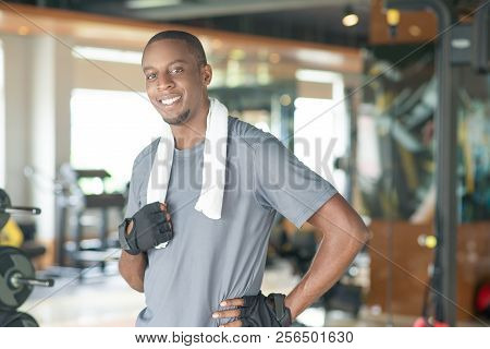 Smiling Sporty Black Man Wearing Towel Around Neck And Looking At Camera. Young Guy Wearing T-shirt 