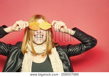 Smiling Model With Stylish Hair In Scarf. Girl With Orange Leaves On Pink Background. Season And Aut