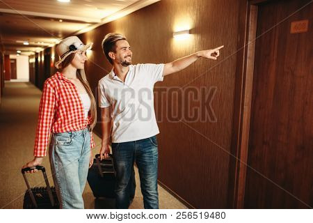 Couple with suitcases looking for their hotel room
