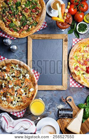 Breakfast Gourmet Pizzas With Eggs, Ham And Lox On The Table Overhead View With Copyspace