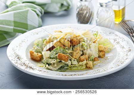 Ceasar Salad For Lunch With Salt And Pepper On The Table