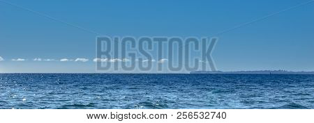 Thin White Cloud Above Distant Horizon Blue Sky And Sea Tones Blending Ideal Use As Background Image